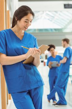 Medical student taking notes in hallway at the university