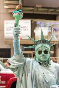 NEW YORK CITY - JUNE 9, 2013: Man in Times Square pretends to be Statue of Liberty. Times Square is a popular tourist destination in New York City.