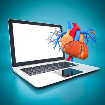 model of heart and white laptop on a blue background