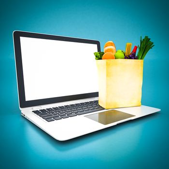 Paper bag with food and white laptop on a blue background