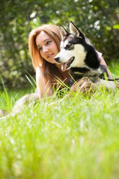 Young woman and her husky in the forest