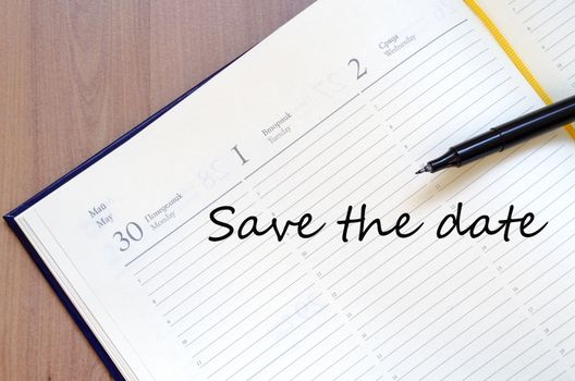 Yellow blank notepad on office wooden table Save the date concept