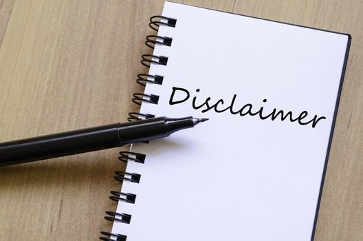 White notepad and ink pen on the wooden desk Disclaimer Concept Notepad