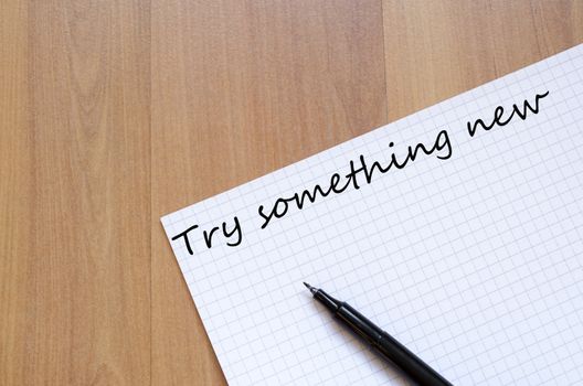White blank notepad on office wooden table Try something new concept