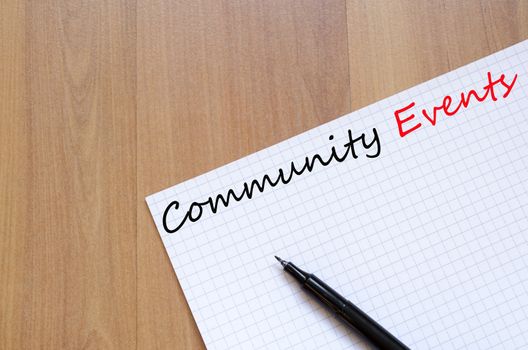 White blank notepad on office wooden table Community Events concept