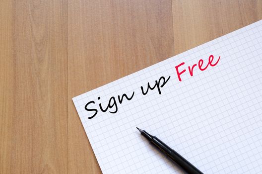 White blank notepad on office wooden table Sign up free concept