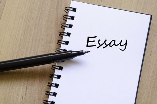 White notepad and ink pen on the wooden desk Essay Concept Notepad