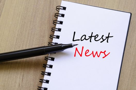 White notepad and ink pen on the wooden desk Latest News Concept