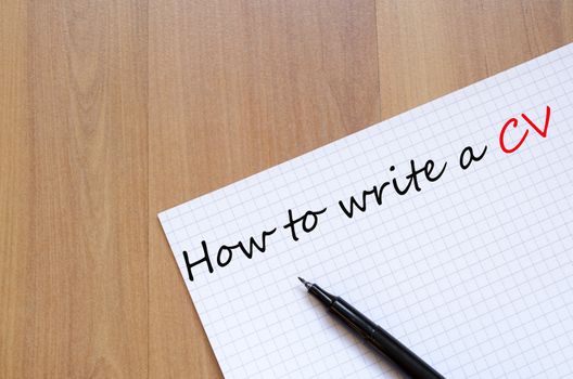 White blank notepad on office wooden table How to write a cv concept