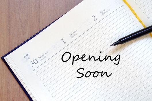 Yellow blank notepad on office wooden table Opening soon concept