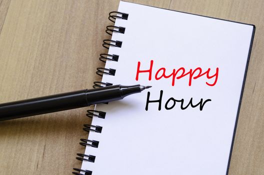 White notepad and ink pen on the wooden desk Happy Hour Concept