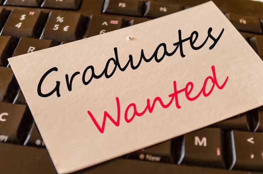 Graduates wanted Concept on black keyboard