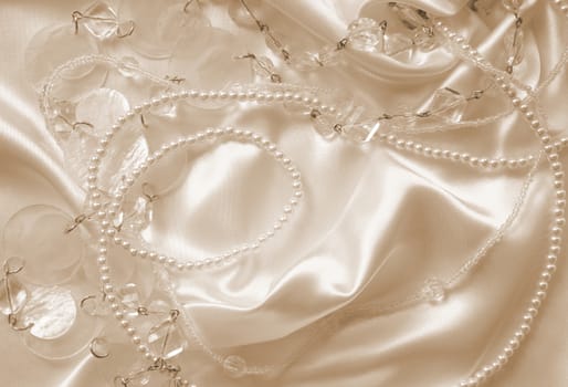 Pearls and nacreous beeds on silk or satin as wedding background. In Sepia toned. Retro style