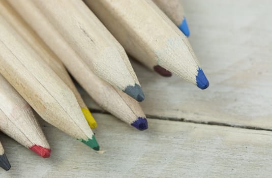 Close f of coloured pencils against a wooden background