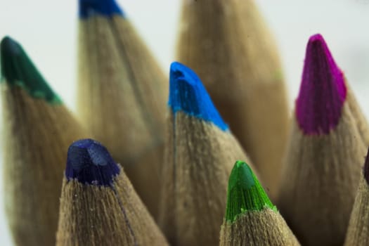 Close f of coloured pencils against a wooden background