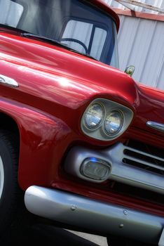 A beautifully restored truck parked outside in the nice sunshine.