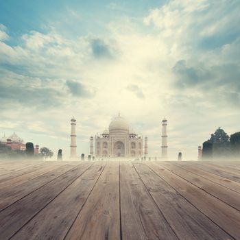 Taj Mahal India Sunrise foggy view from wooden platform.