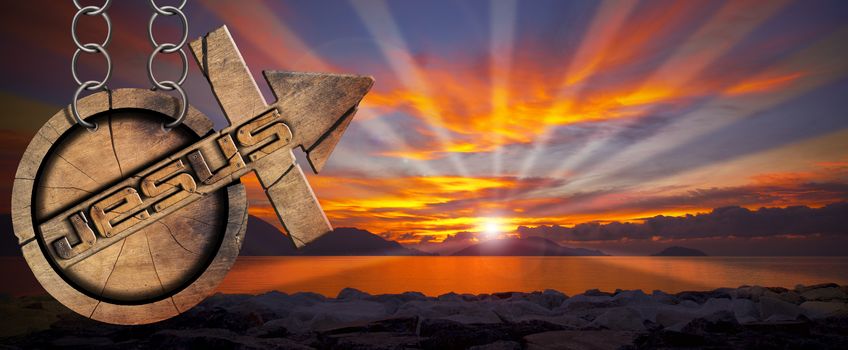 Wooden symbol with cross and arrow upward and text Jesus. Hanging from a chain at a beautiful sunset over the sea with cloudy sky