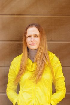 Beautiful fashionable girl in a jacket  in autumn on a background of a wall