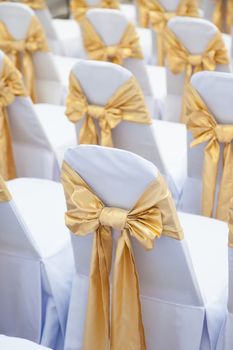 Indoor wedding. White cloth cover with a cloth and tied with a bow decorations.