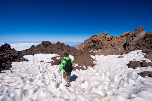 Man hiking. Young  guy hiking / backpacking in the rough  volcanic landscape on the volcano, Teide, highest peak of Spain.