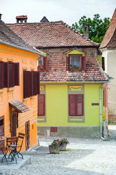 Sighisoara, Romania - June 23, 2013: Stone paved old street with colored houses from Sighisoara fortresss, Transylvania, Romania