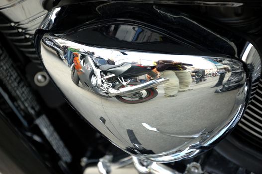 Closeup photo of motorbike engine with shiny chrome parts, different metal components.