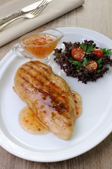 Chicken breast with sweet and sour sauce salad garnish on a plate