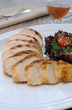 slices of chicken grilled with a salad on a plate