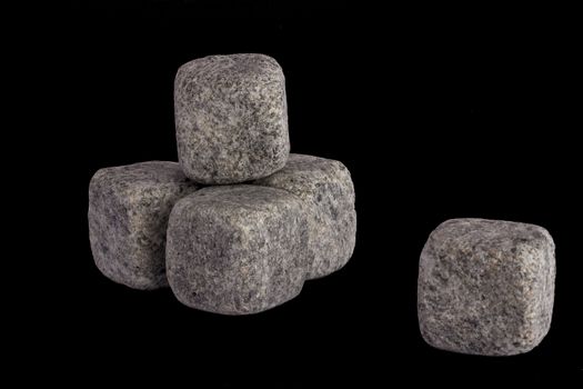 four whiskey stones stacked in a pyramid and one separate stone