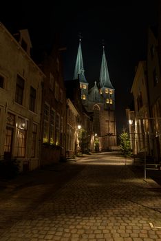 Illuminated church of the city of Deventer in the center of the Netherlands because of a special Char-les Dickens weekend. The Dutch place Deventer has annually at the end of the year around Christmas a dickens weekend. The old city centre is completely free of car traffic and the residents are his-torically dressed up