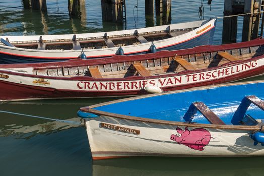 Colored rowing boats in the harbor of West Terschelling on the island of Terschelling in the Nether-lands