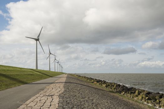 Modern windmills in the so called Noordoostpolder nearby the dyke of the IJsselmeer in the Netherlands