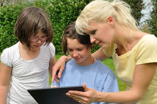 Family sitting on the lawn and using digital tablet