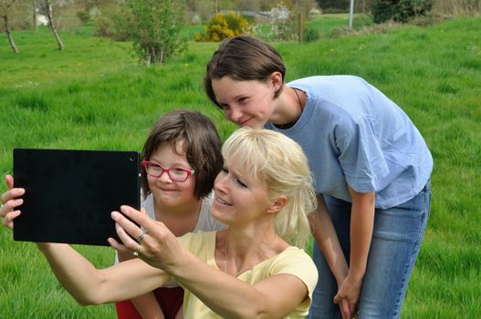 Family sitting on the lawn and using digital tablet