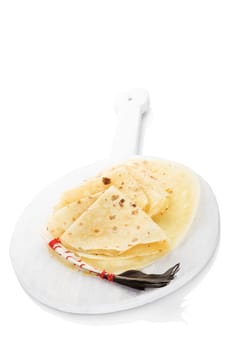 Lokse, european salty pancakes on wooden kitchen board isolated on white background. Culinary easter european cuisine.