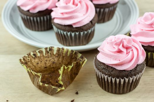 Chocolate flavored cupcakes frosted with pink buttercream frosting.