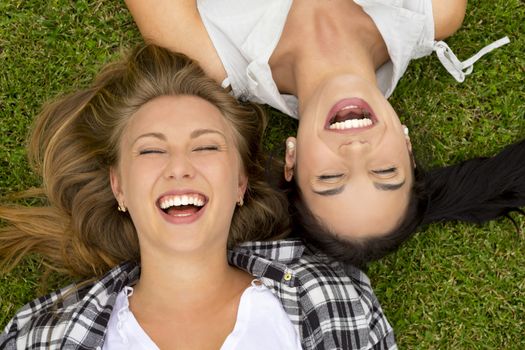 Female best Friends lying on the grass and laughing