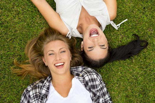 Female best Friends lying on the grass and laughing