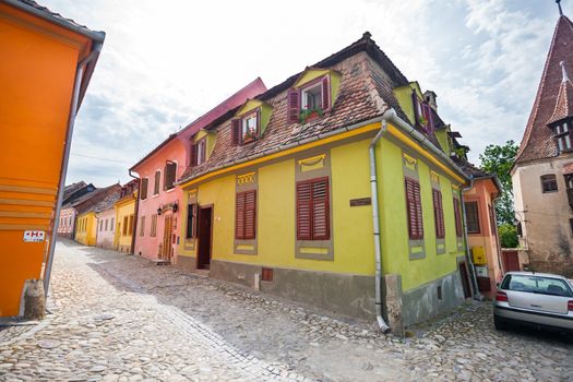 Sighisoara, Romania - June 23, 2013: Stone paved old streets with colored houses from Sighisoara fortresss, Transylvania, Romania