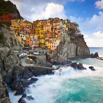 Manarola fisherman village in a dramatic windy weather. Manarola is one of five famous colorful villages of Cinque Terre in Italy, suspended between sea and land on sheer cliffs upon the wild waves.