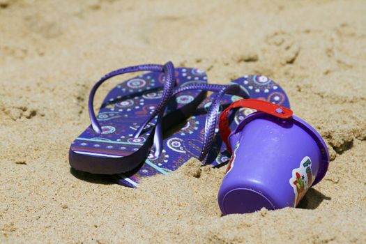 Children's sandy toys and flip-flop on a beautiful beach. India Goa.