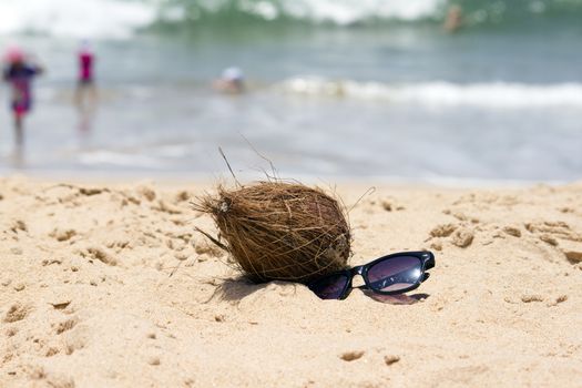 Coconut  and a sunglasses on a beautiful beach. India Goa.
