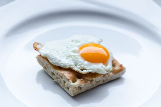 Little Quail egg than  toast on a white plate.