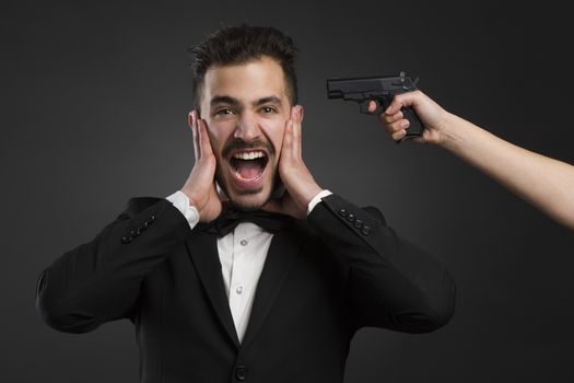 Man yelling with a weapon pointing on his head 