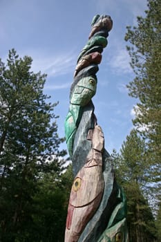 A totem pole with fish in the forest
