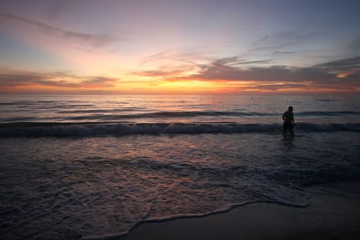 A stunning sunset over the ocean with person gazing