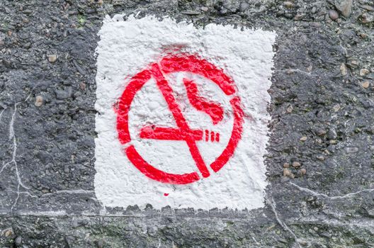 No smoking symbol sprayed on an ancient concrete wall.