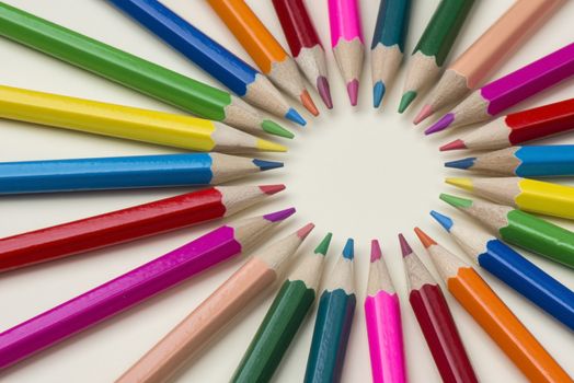 Abstract composition of a set wooden colour pencils against a white background