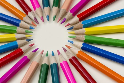 Abstract composition of a set wooden colour pencils against a white background